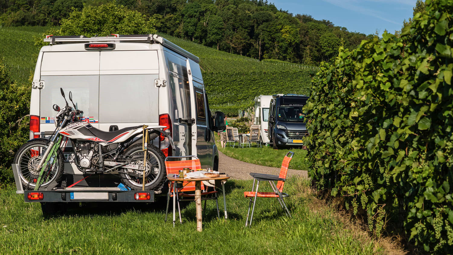 Ein Camper mit einem Motorrad auf dem Heckträger