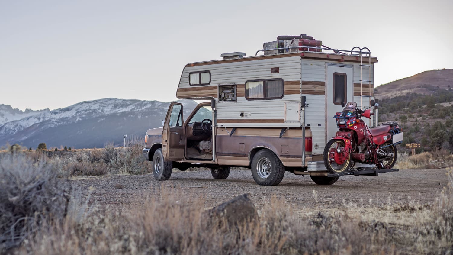 Ein Camper mit einem Motorrad auf dem Heckträger