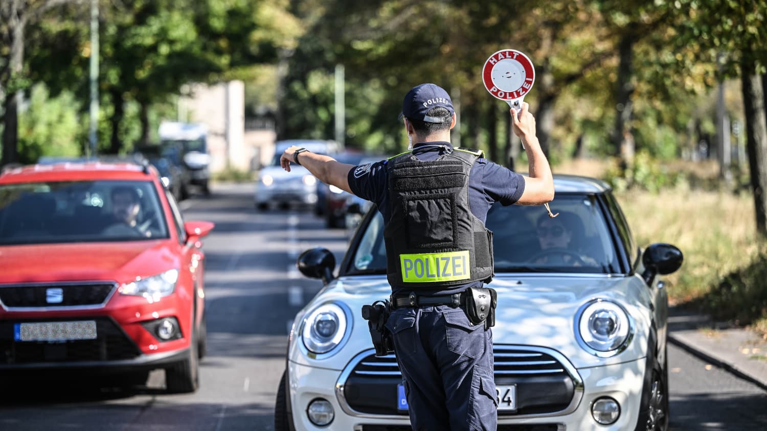 Ein Polizist winkt Autos bei einer Verkehrskontrolle raus