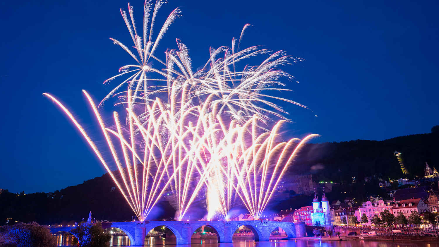 Mit bunten Feuerwerkskörpern über dem Heidelberger Wahrzeichen Alte Brücke wird die erste Schlossbeleuchtung im Jahr 2019 gefeiert