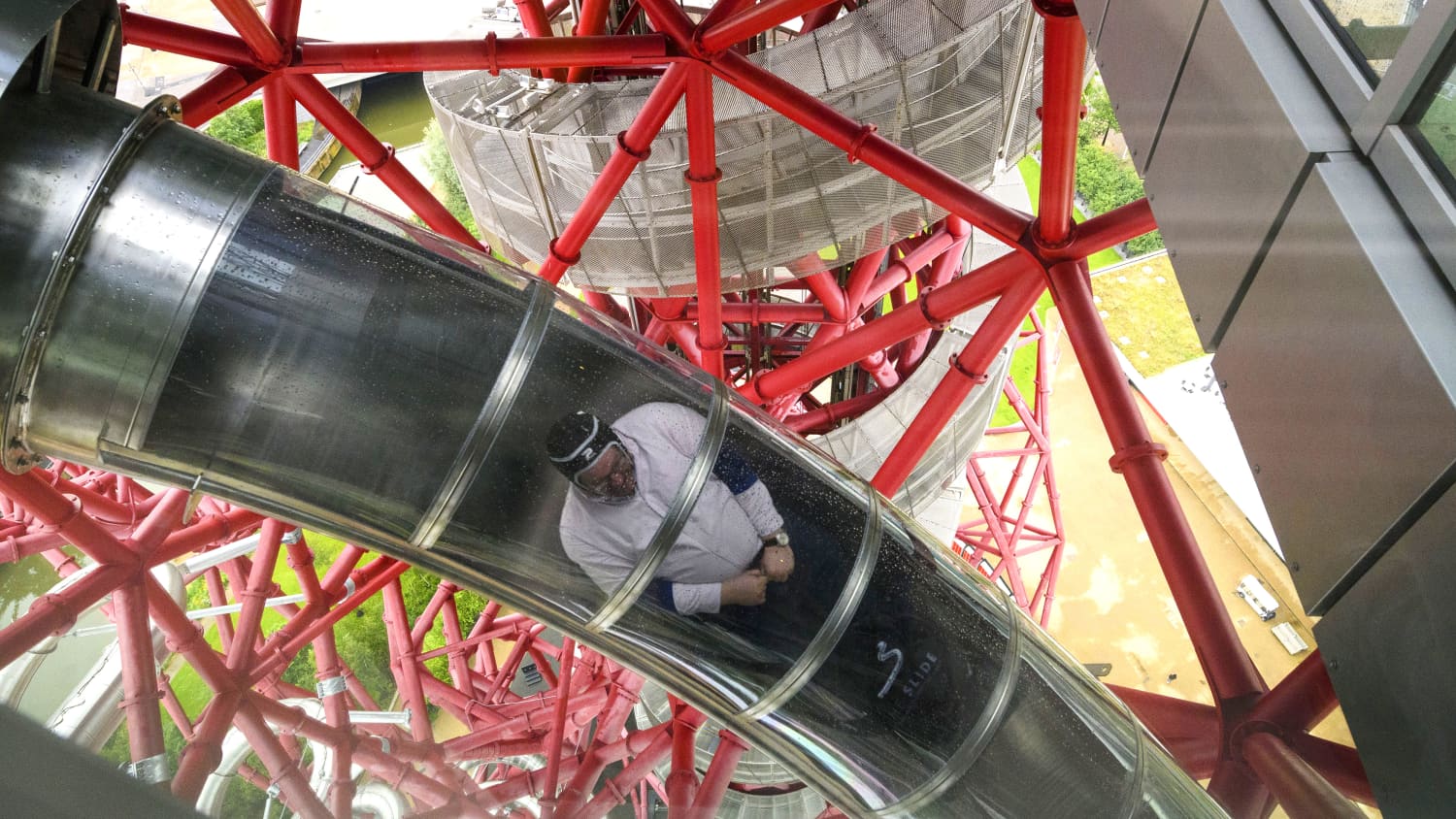 Mann rutscht die Rutsche am ArcelOrmital Orbit hinunter