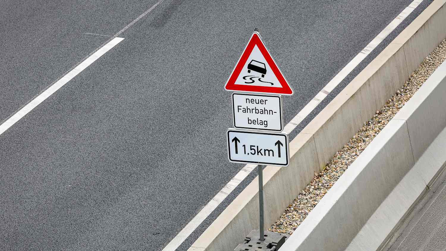 Ein "Neuer Fahrbahnbeleg"-Hinweisschild an einer Autobahn