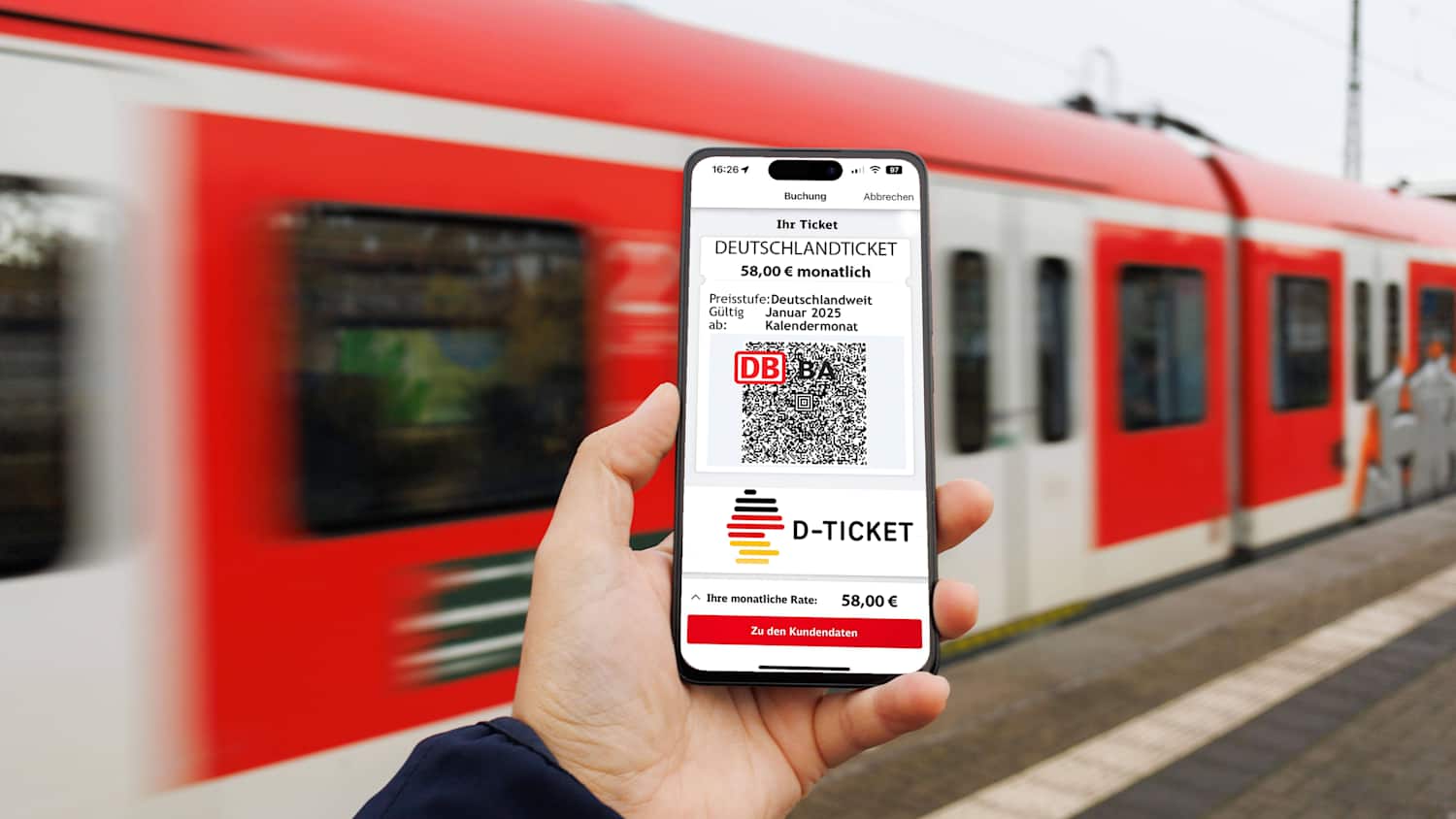 Ein Mann hält sein Handy in der Hand auf dem das Deutschlandticket zu sehen ist. Im Hintergrund fährt ein Zug vorbei