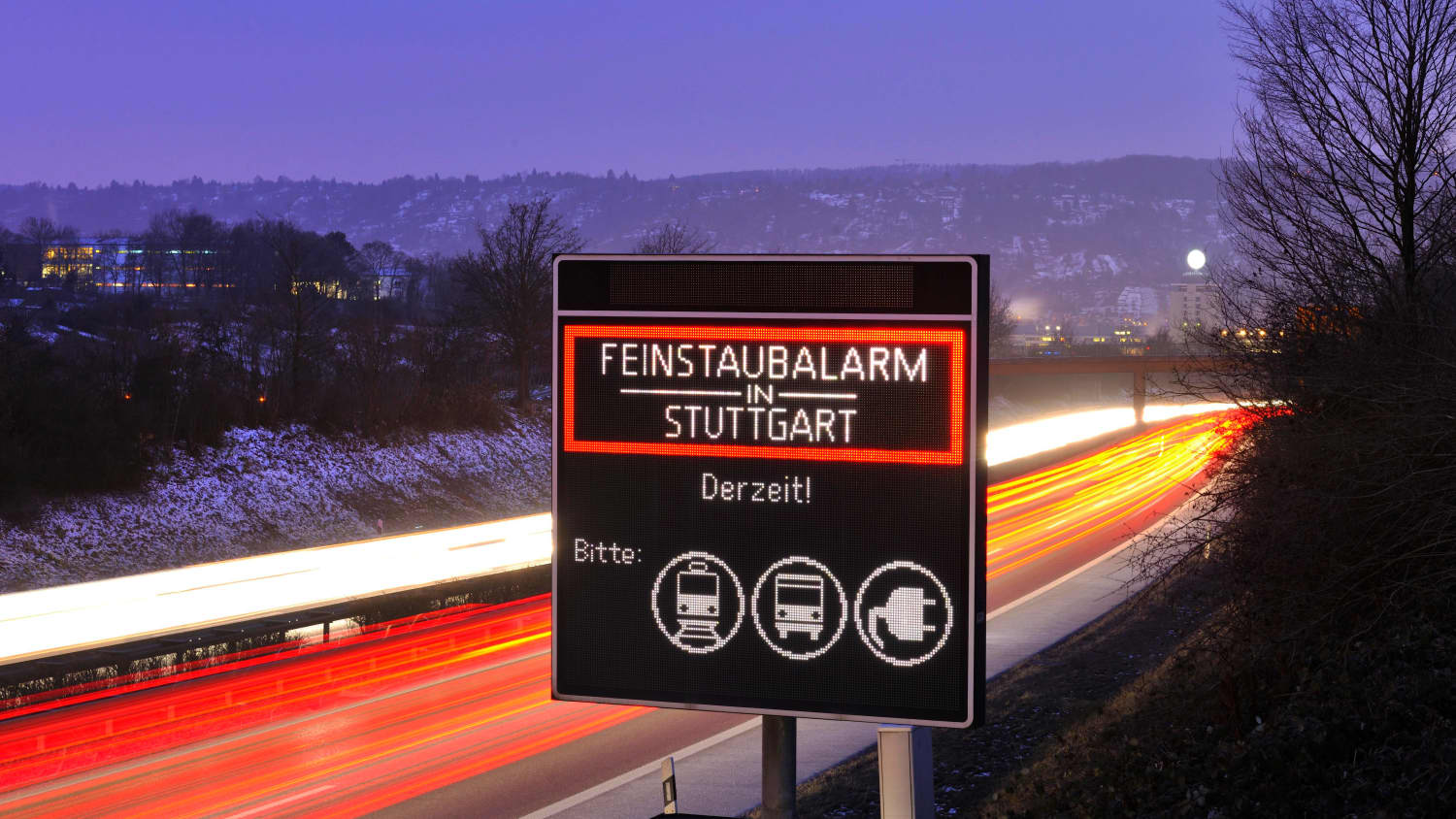 Leuchtendes Schild zu Feinstaubalarm in Stuttgart an Winterabend