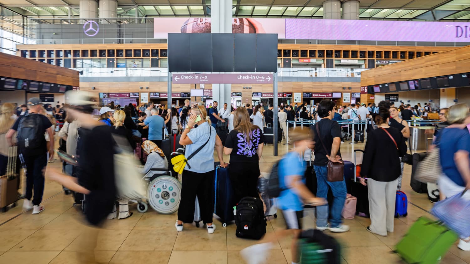 Zahlreiche Fluggäste warten am Hauptstadtflughafen BER vor einer schwarzen Anzeigetafel. Am Flughafen BER ist der Flugverkehr eingestellt worden. Als Grund dafür werden technische Probleme genannt.