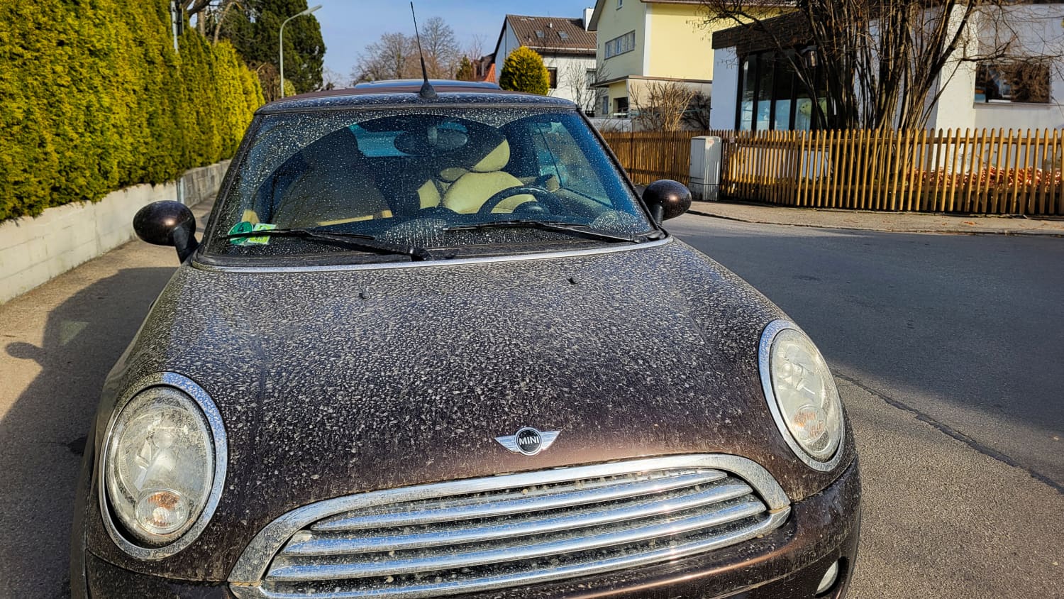 Saharastaub auf einem schwarzen Mini der an einer Straße parkt