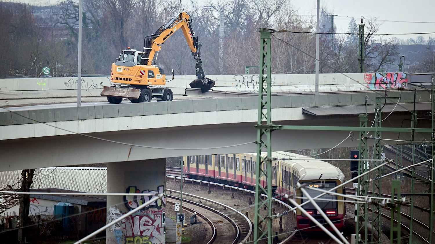 Ein Bagger räumt Fahrbahnbegrenzungen auf der Ringbahnbrücke zur Seite. Die Brücke der A100 im Westen Berlins ist aus Sicherheitsgründen in nördlicher Richtung voll gesperrt.
