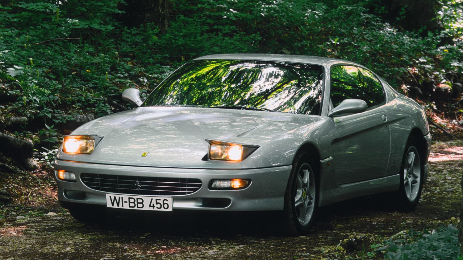 Der Ferrari 456 steht auf einem Waldweg
