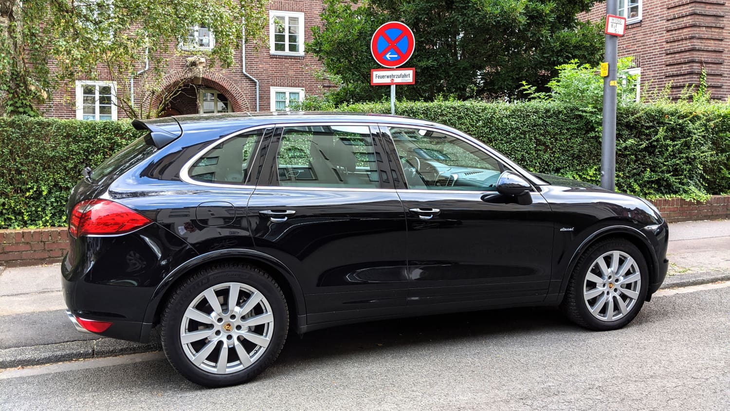 Ein Porsche Cayenne parkt im absoluten Halteverbot einer Feuerwehreinfahrt.