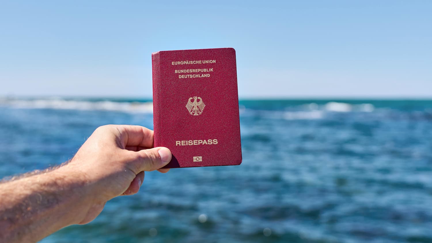 Ein Mann der einen Reisepass in der Hand hält