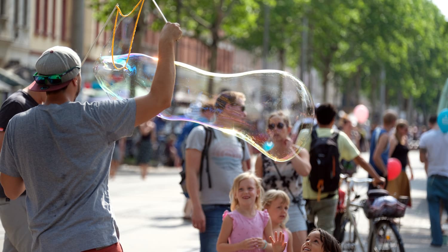 Ein Mann macht eine riesige Seifenblase bei enem  Straßenfest im Stadteil Plagwitz in Leipzig