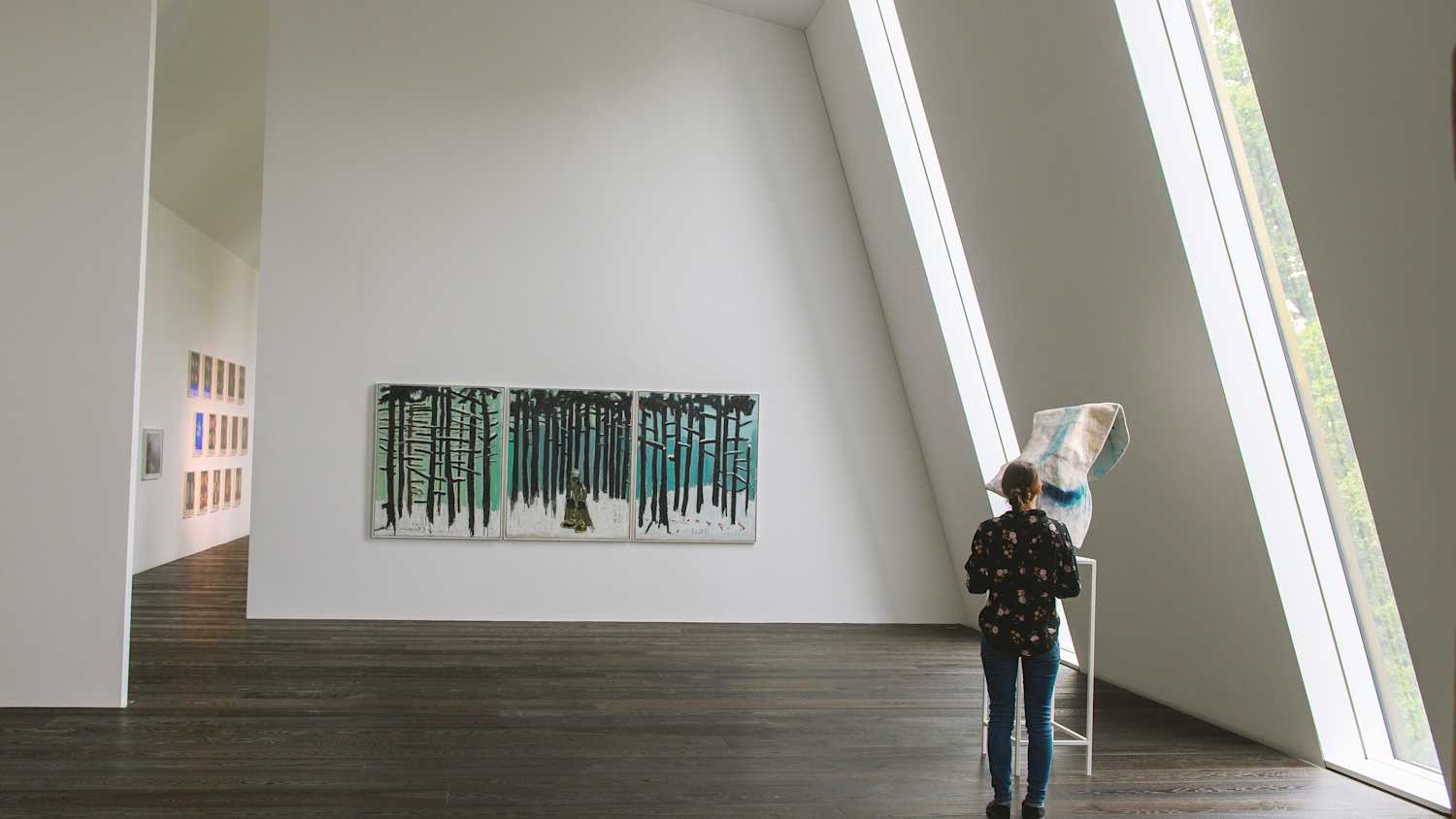 Eine Frau sieht sich im neuen Anbau vom Kunstmuseum Kloster Unser Lieben Frauen in Magdeburg ausgestellte Kunstwerke an.