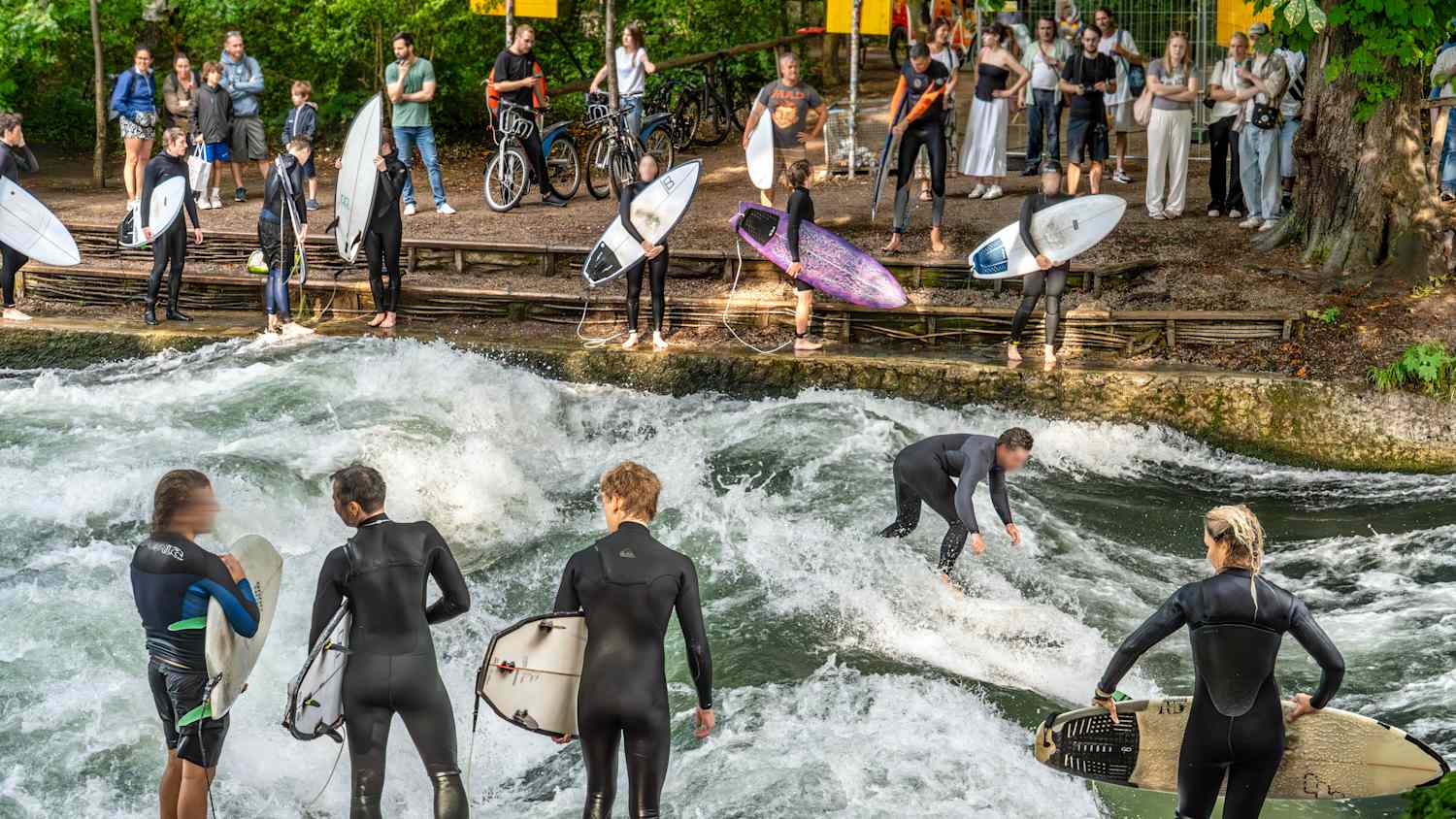 Surfer an der Eisbachwelle in München nach der Wiedereröffnung