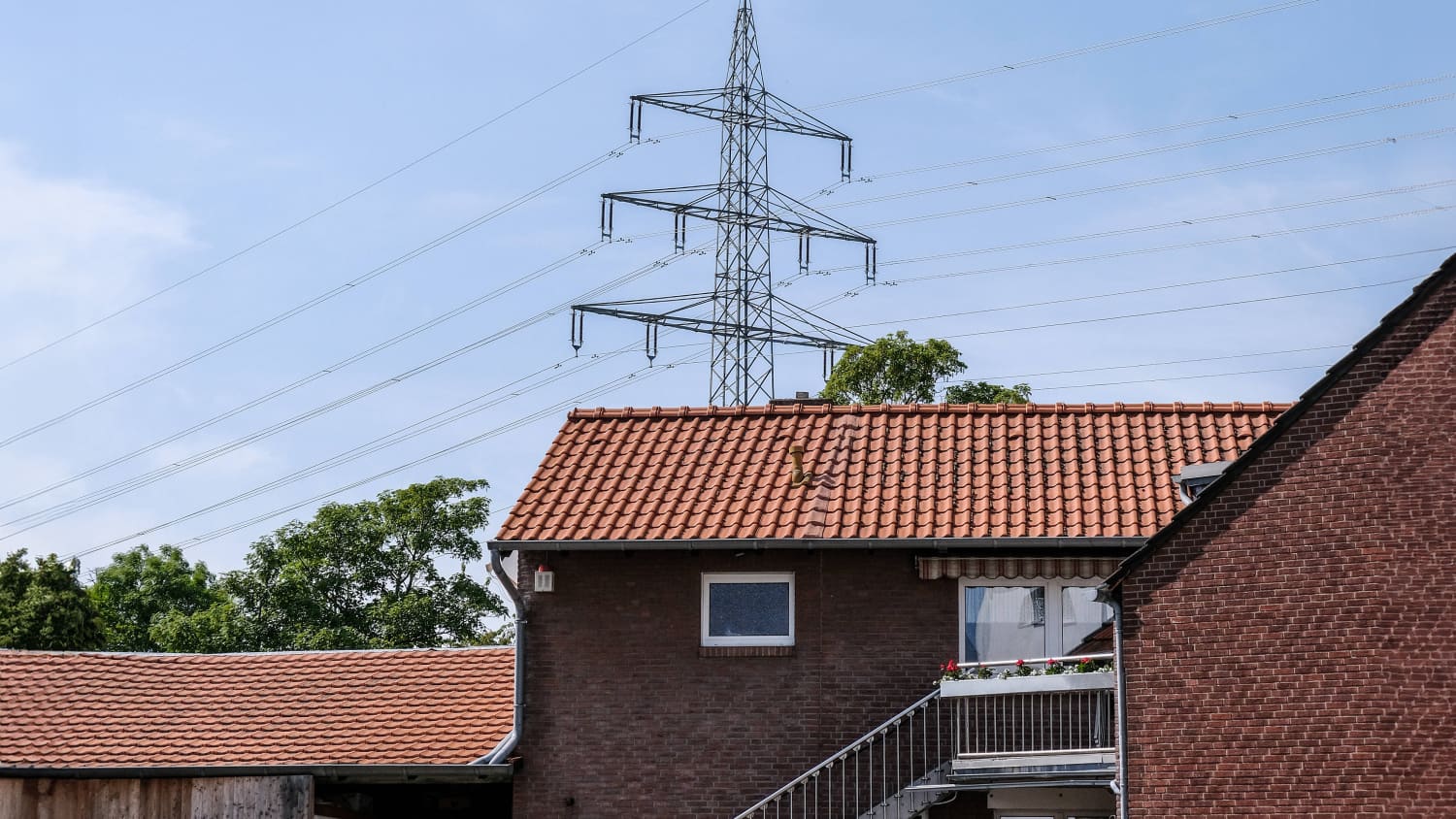 Strommast vor Wohnhäusern