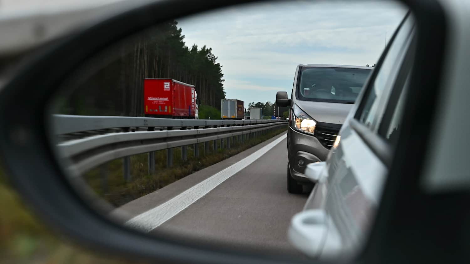 Viel zu dicht aufgefahren ist ein Kleintransporter, der im Außenspiegel eines Pkw zu sehen ist, auf der linken Fahrspur einer Autobahn.