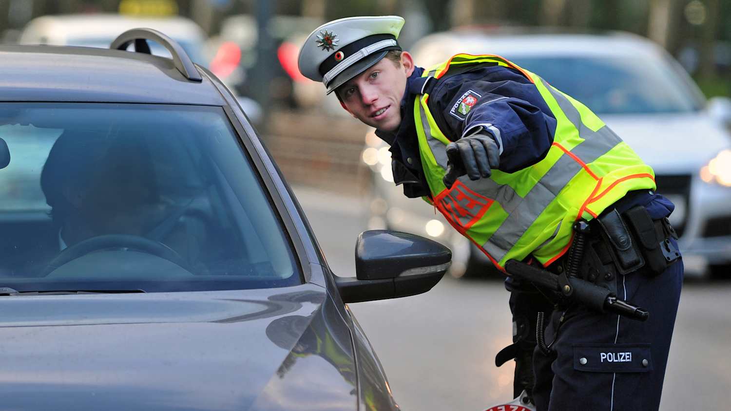 Ein Polizist hält  in Düsseldorf (Nordrhein-Westfalen) ein Fahrzeug aufgrund einer Geschwindigkeitsüberschreitung an.