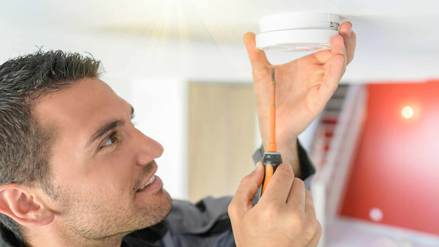 Ein Rauchmelder wird an die Decke montiert