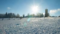 Blick auf verschneite Landschaft in Dobel mit Menschen, die Schlitten fahren