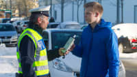 Polizist führt einen Alkoholtest bei einem jungen Autofahrer durch