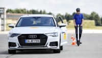 Ein E-Scooter Fahrer nähert sich einem Audi auf der ADAC Teststrecke