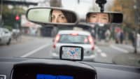 Frauen blicken während Fahrstunde in den Rückspiegel
