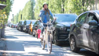 Junge Frau telefoniert mit ihrem Handy während sie Fahrrad fährt