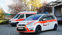 Ein Notarztwagen und ein Krankentransportwagen vor der Johanniter Fuhrparkgarage