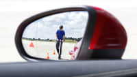 Ein E-Scooter Fahrer ist in einem Rückspiegel auf der ADAC Teststrecke zu sehen