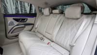 Die elegante Rückbank des neuen weißen Mercedes EQS 580 4MATIC mit den weißen Gurten und Ledersitzen