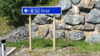 Ein neues Holz-Verkehrsschild in Österreich mit Pfeil zur Autobahn A2 Richtung Graz