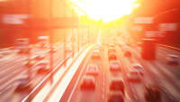 Viele Autos fahren auf einer Autobahn der Sonne entgegen.