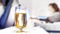 Ein Glas Wein steht für einen Fluggast im Flugzeugb ereit