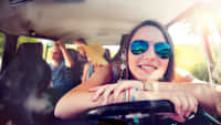 junge Frau am Lenkrad mit Sonnenbrille