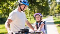 Vater kommuniziert mit Tochter im Fahrradsitz