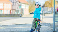 Kind mit Rad auf dem Gehweg