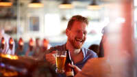 Ein junger Mann trinkt Bier in einer Bar
