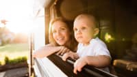Frau guckt mit ihrem Baby aus dem Wohnwagenfenster