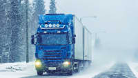 LKW fährt auf schneebedeckter Straße