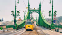 Eine Strassenbahn fährt über eine Brücke in Budapest.