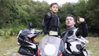 Vater und Kind stehen beim Motorrad