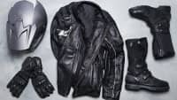 Ein Motorradhelm, Handschuhe, eine Lederjacke sowie Motorradstiefel von oben auf dem Boden