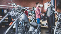 Zwei Männer in einem Motorradladen schütteln sich die Hände.
