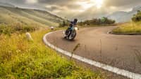 Motorradfahrer kurvt auf Landstrasse im Alpenvorland