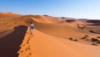 Frau wandert auf Düne in Namibia