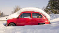 Ein Oldtimer Fiat 500 steht tief im Schnee