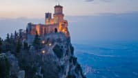 Eine Burg in San Marino auf dem Berggipfel im Abendlicht