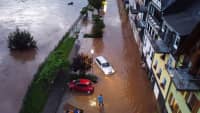 Autos versuchen auf der überfluteten Straße vorwärts zu kommen