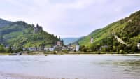 Blick über den Rhein auf Bad Bacherach im Sommer mit Stadtmauer und Burg Stahleck