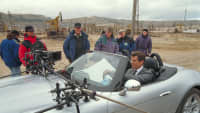 Eine Filmszene aus James Bond mit Pierce Brosnan, der in einem Auto sitzt