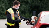 Polizist kontrolliert Papiere eines Autofahrers